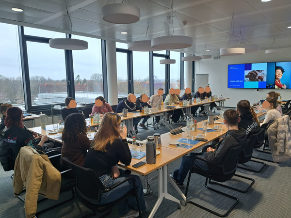 mehrere Leute sitzen an einem großen Tisch