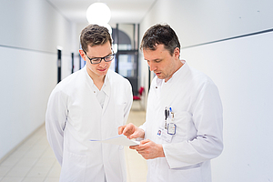 zwei Ärzte schauen auf Flur in eine Akte, radiologie rostock 